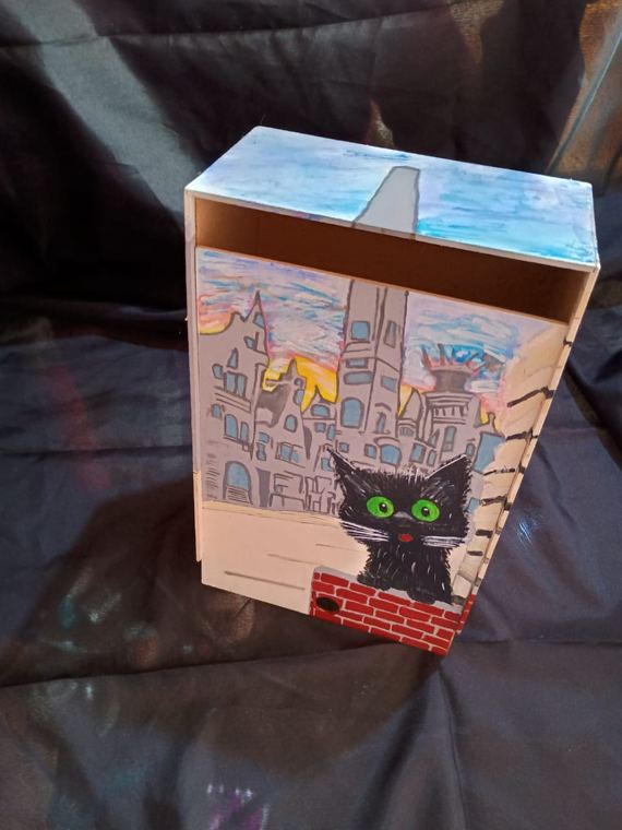 Caja con gato negro sobre la ciudad