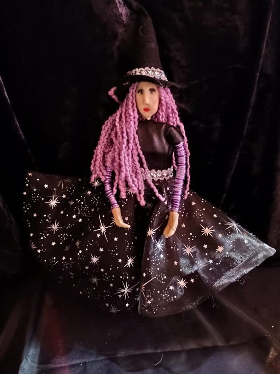 Bruja de cabello lila con falda de estrellas