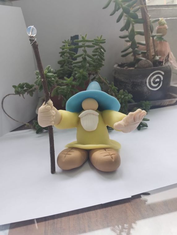 Mago de sombrero azul y túnica amarilla con báculo de cristal