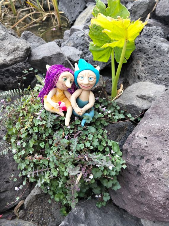 Pareja de duendes, ella de cabello morado y él de gorro turquesa